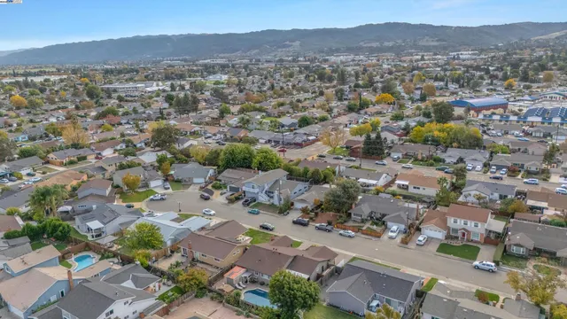 an aerial view of a city with lots of residential buildings and mountain view in back