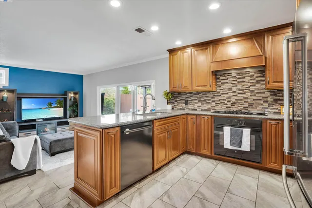 a kitchen with stainless steel appliances granite countertop a stove a sink and a microwave