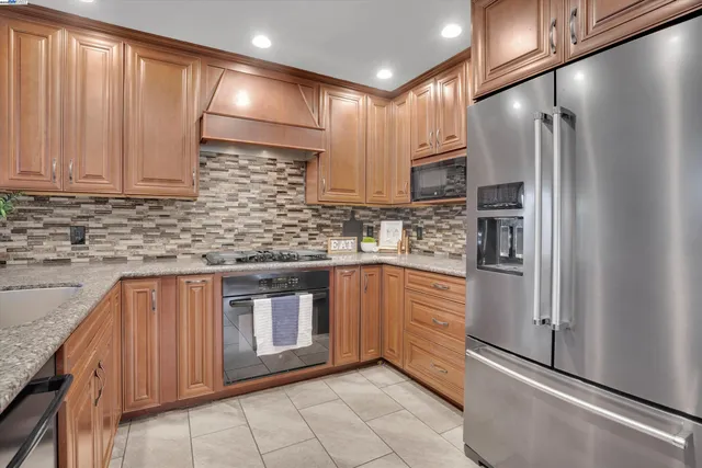 a kitchen with stainless steel appliances granite countertop a refrigerator sink and cabinets