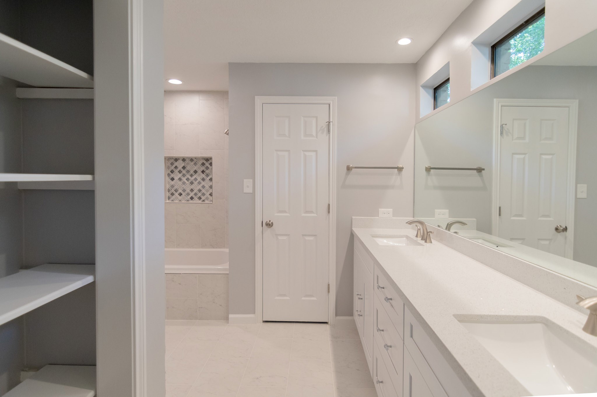 10 Coralvine Court Spring, TX 77380 - Photo 22 of 34 Gorgeous primary bathroom has double vanity areas with quartz counters and ample cabinet and shelf storage, silver fixtures and high windows.