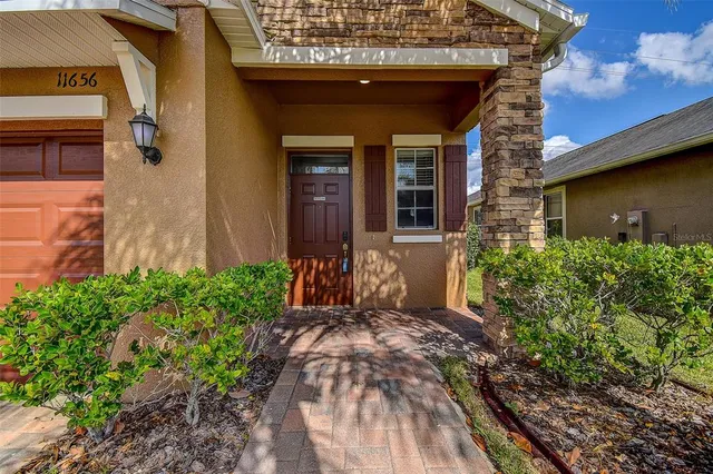a kitchen with stainless steel appliances granite countertop a refrigerator a stove and a sink with wooden cabinets