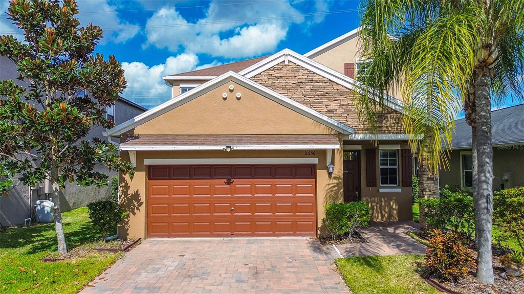 11656 Lake Boulevard New Port Richey, FL 34655 - Photo 42 of 55 a front view of a house with a yard and garage