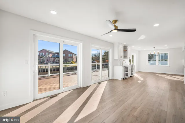 a view of a livingroom with wooden floor and a ceiling fan