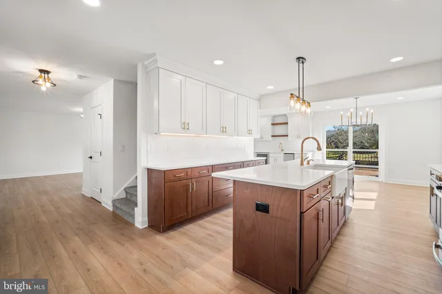 a kitchen with kitchen island granite countertop a sink and a stove top oven