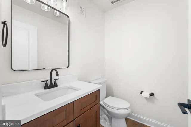 a bathroom with a sink toilet and mirror