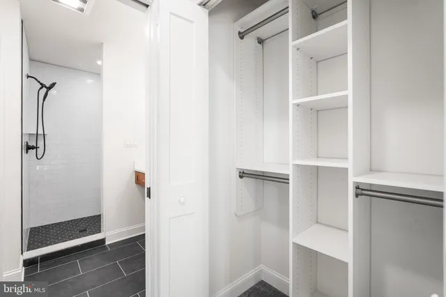 a view of walk in closet with empty racks