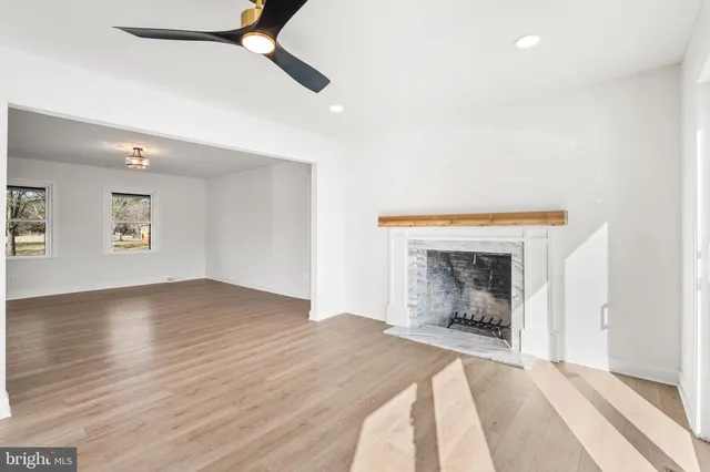 an empty room with windows and fireplace