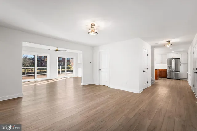 a view of a big room with wooden floor and windows