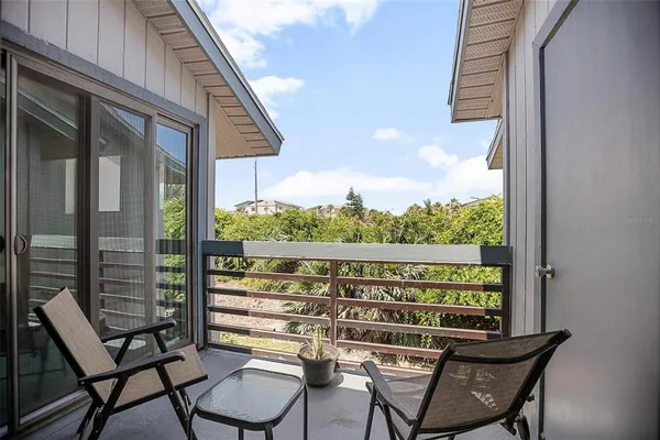 a view of a chairs and table in the balcony