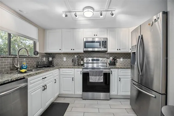 a kitchen with stainless steel appliances cabinets a sink and a stove