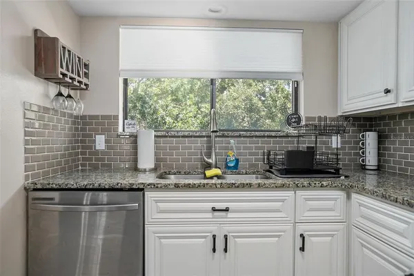 a kitchen with granite countertop a sink and a window