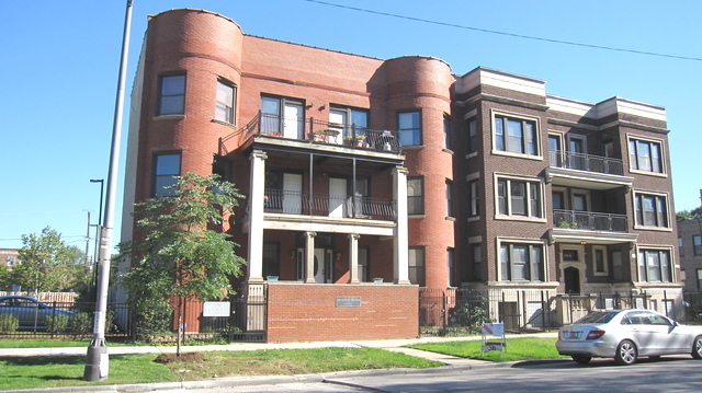 a front view of a residential apartment building with a yard