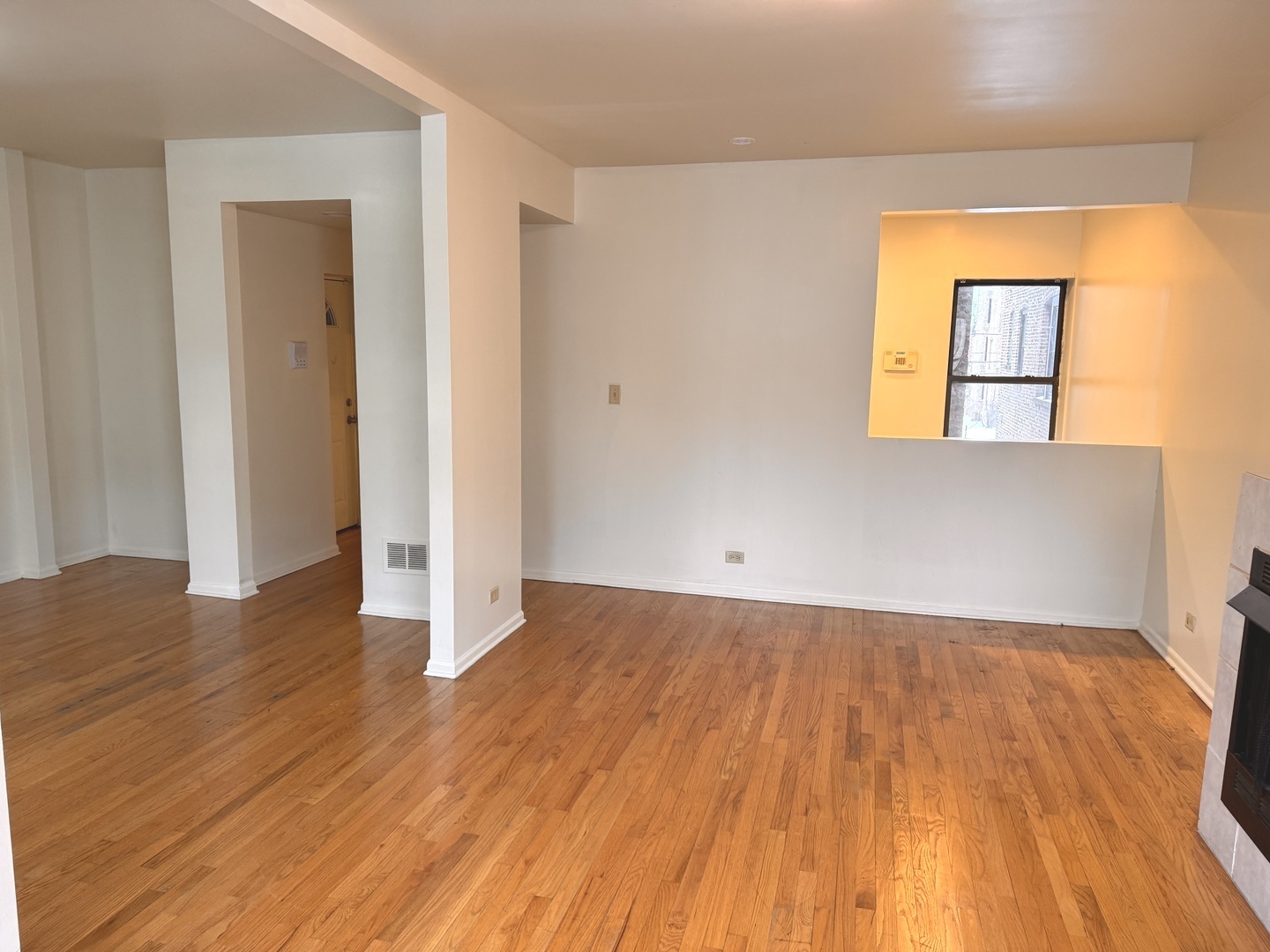 4615 South Michigan Avenue, Unit 2S Chicago, IL 60653 - Photo 11 of 26 an empty room with wooden floor and a window