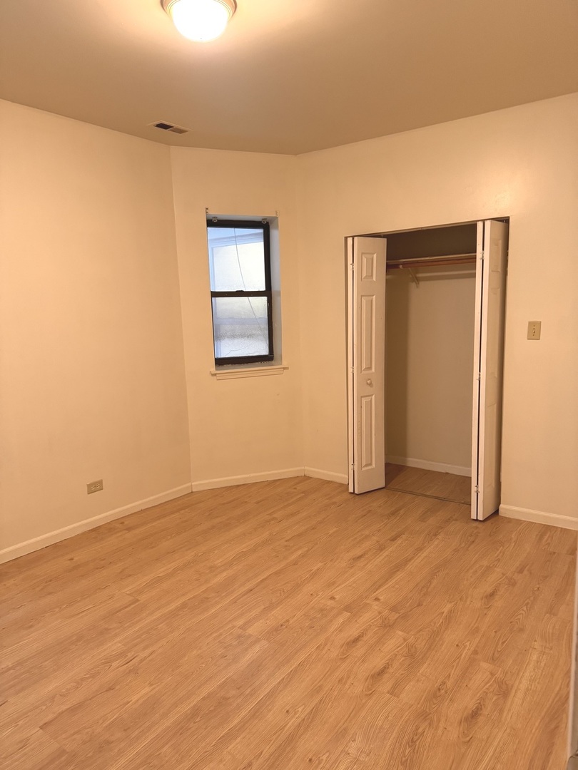 4615 South Michigan Avenue, Unit 2S Chicago, IL 60653 - Photo 13 of 26 a view of an empty room with wooden floor and a window