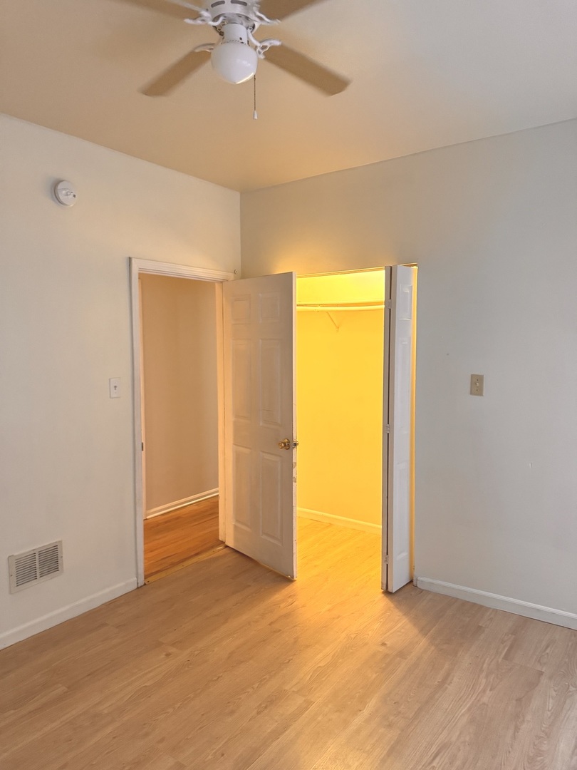 4615 South Michigan Avenue, Unit 2S Chicago, IL 60653 - Photo 16 of 26 an empty room with a ceiling fan and a window