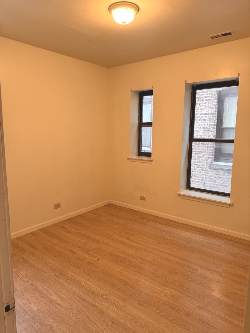 4615 South Michigan Avenue, Unit 2S Chicago, IL 60653 - Photo 18 of 26 a view of an empty room with wooden floor and a window