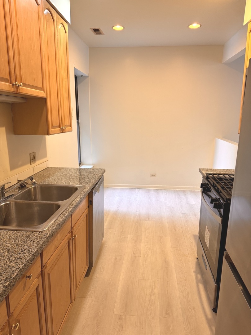 4615 South Michigan Avenue, Unit 2S Chicago, IL 60653 - Photo 4 of 26 a kitchen with kitchen island a sink a stove and a refrigerator