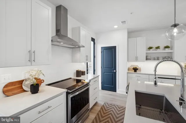 a kitchen with stainless steel appliances kitchen island granite countertop a sink and a refrigerator