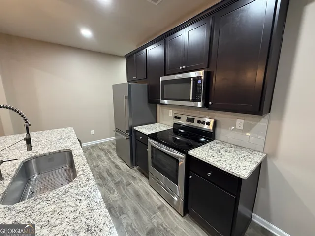 a kitchen with granite countertop stainless steel appliances and wooden cabinets