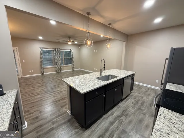 a spacious bathroom with a granite countertop sink a mirror and shower