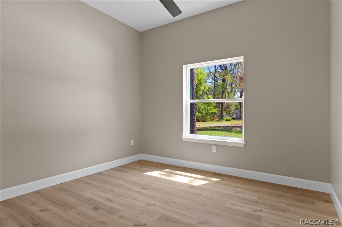 4530 South Florida Avenue Inverness, FL 34450 - Photo 27 of 100 an empty room with wooden floor and windows