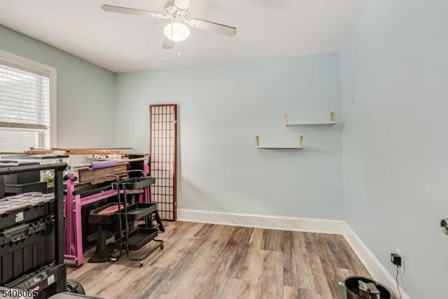 a view of workspace with wooden floor and fan