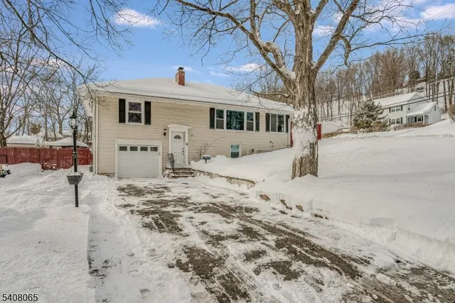 a front view of a house with a yard covered in snow