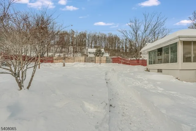 a view of white house with a yard covered in snow