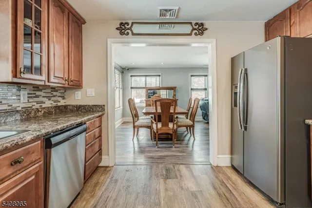 a kitchen with stainless steel appliances granite countertop a refrigerator and a stove top oven