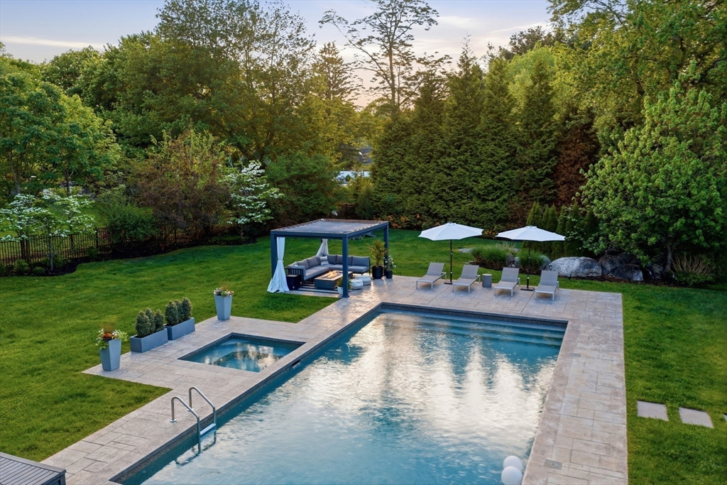 85 Old Farm Road Milton, MA 02186 - Photo 35 of 42 a view of a swimming pool with lawn chairs under an umbrella
