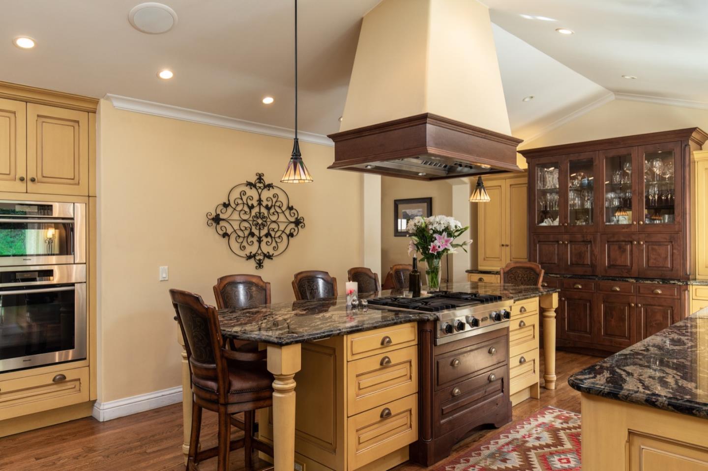 2869 Coyote Road Pebble Beach, CA 93953 - Photo 18 of 35 a kitchen with stainless steel appliances kitchen island granite countertop a table and chairs in it