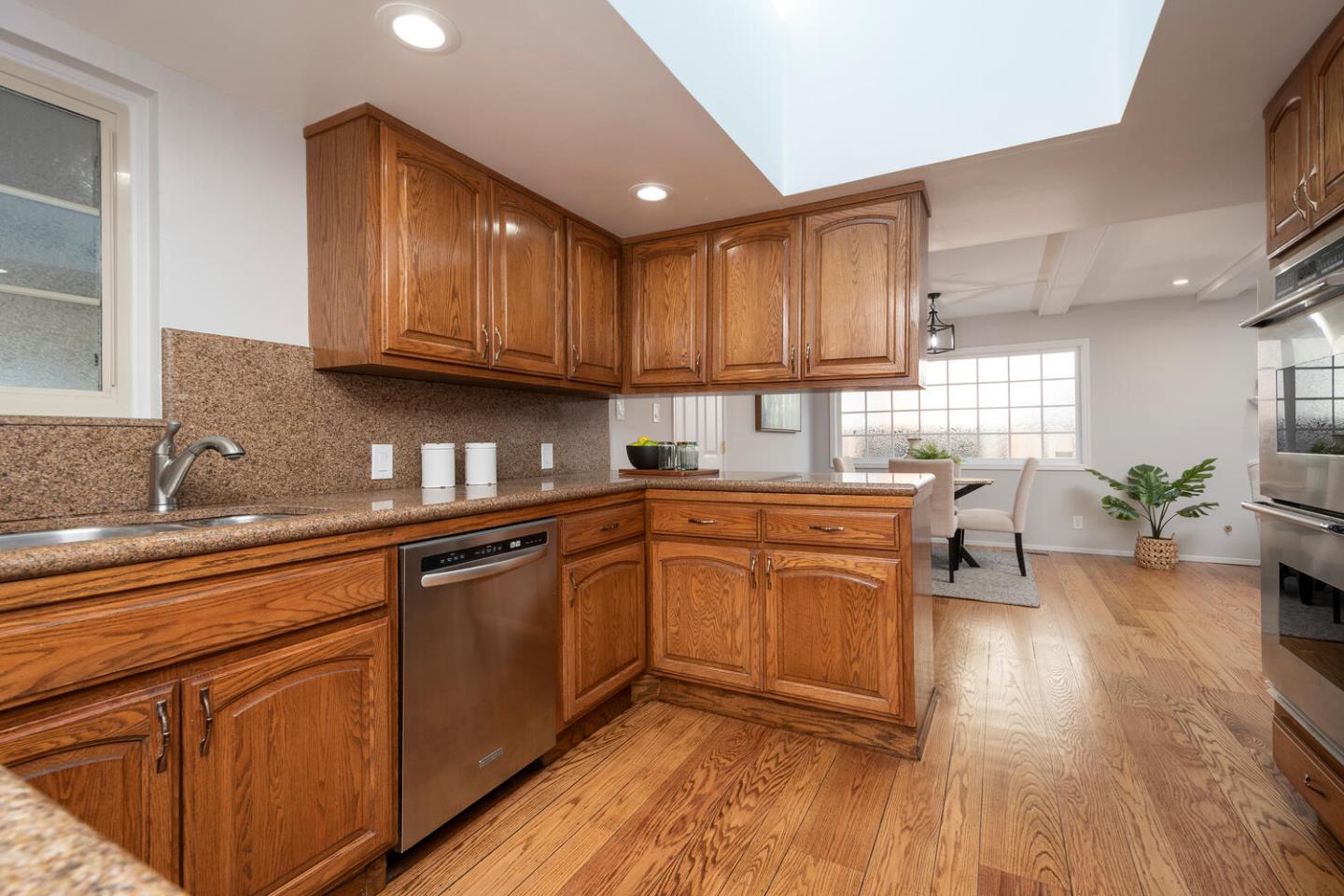 3115 Rivera Drive Burlingame, CA 94010 - Photo 11 of 26 a kitchen with granite countertop wooden floors a sink stainless steel appliances and cabinets