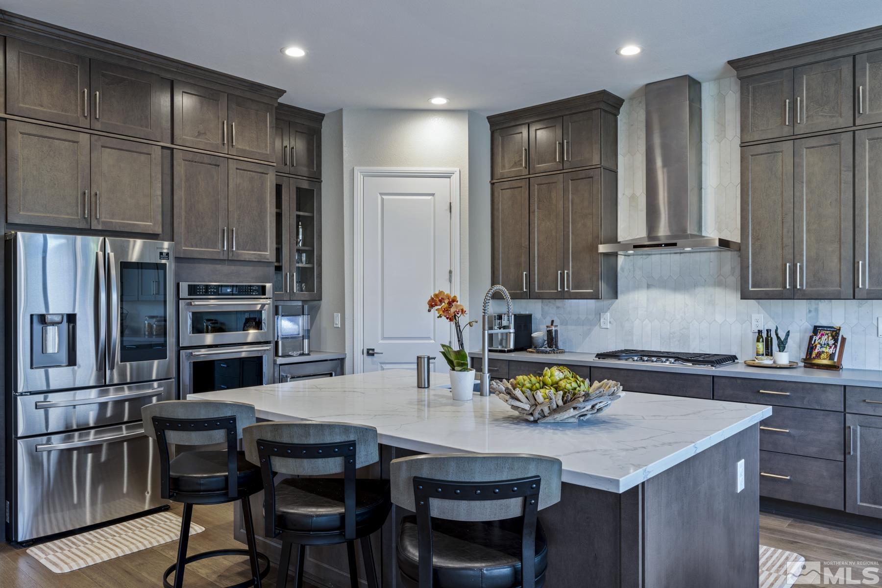 2329 Blushing Rock Drive Reno, NV 89521 - Photo 12 of 40 a kitchen with stainless steel appliances granite countertop a table chairs and a refrigerator