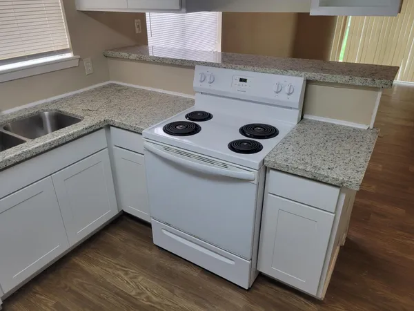 an empty room with wooden floor fan and window