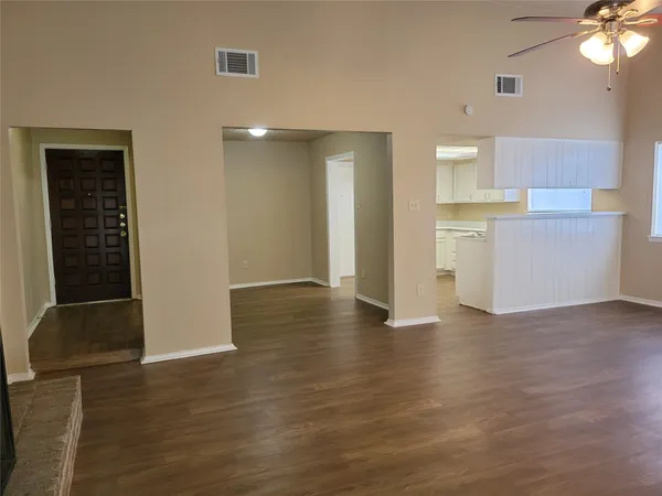 a view of a kitchen with wooden floor and a ceiling fan
