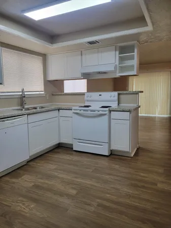 a kitchen with stainless steel appliances granite countertop a sink and cabinets with wooden floor