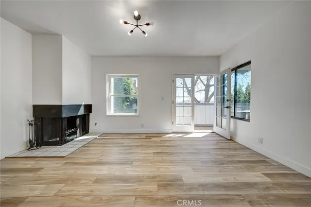 a view of an empty room with a window and fireplace