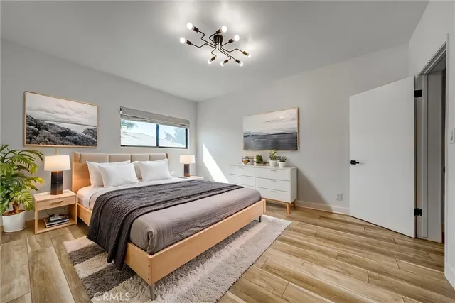 a spacious bedroom with a bed and a chandelier