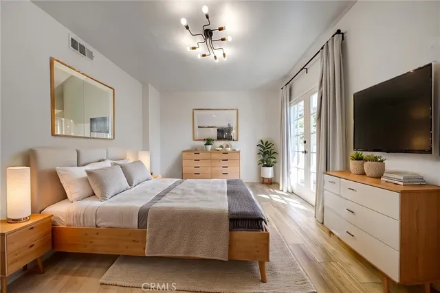 a bedroom with a large bed and a flat screen tv