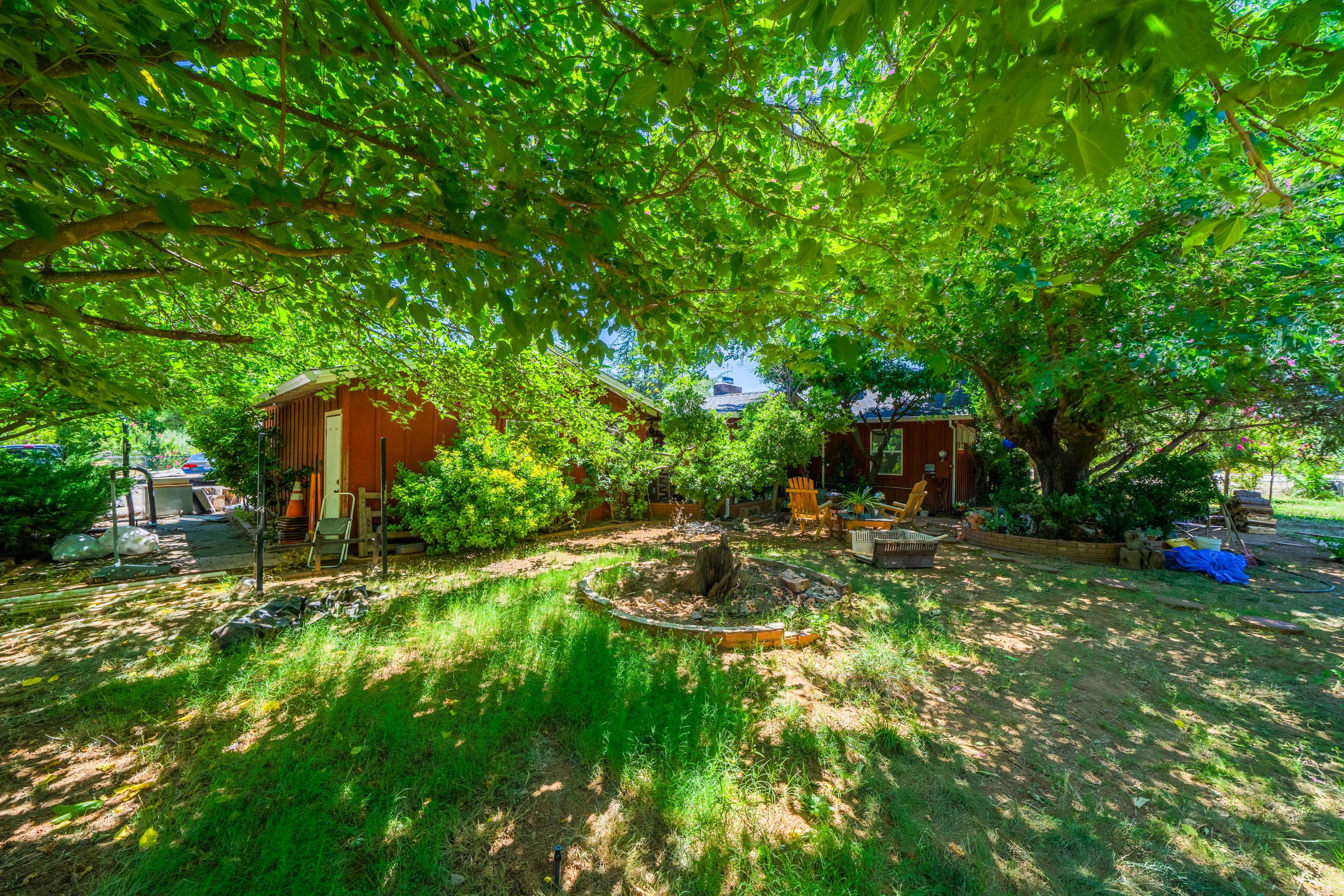 1542 Old Alturas Road Redding, CA 96003 - Photo 19 of 20 a backyard of a house with table and chairs and a large tree