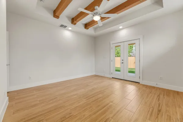 an empty room with wooden floor and windows