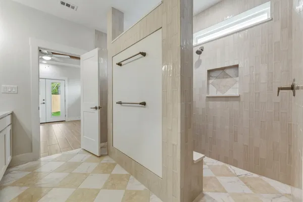 a view of a hallway with wooden floor and a bathroom