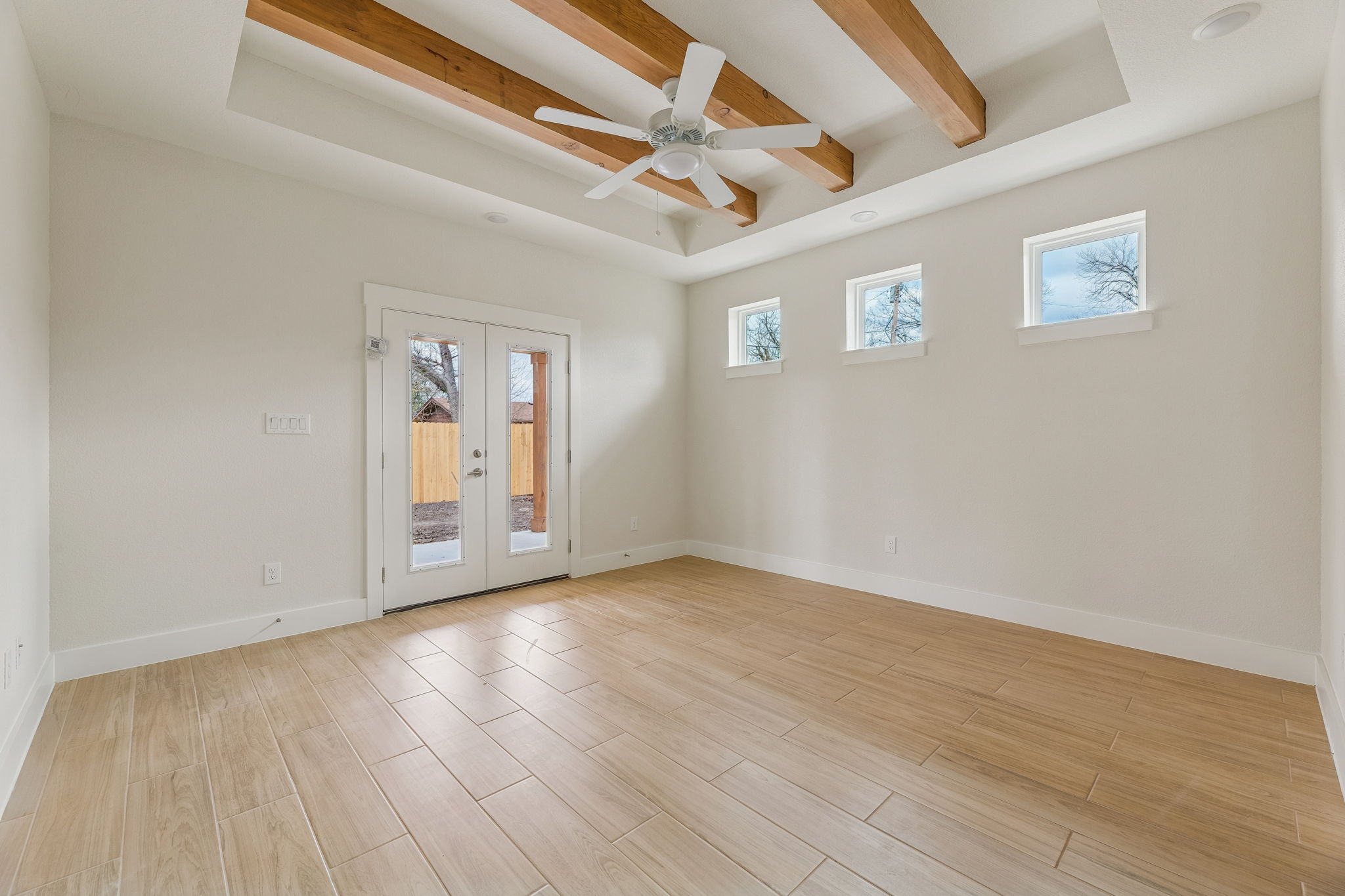 1412 Kent Street Taylor, TX 76574 - Photo 6 of 12 Primary bedroom with double doors to back patio. Beamed ceilings with ceiling fan.