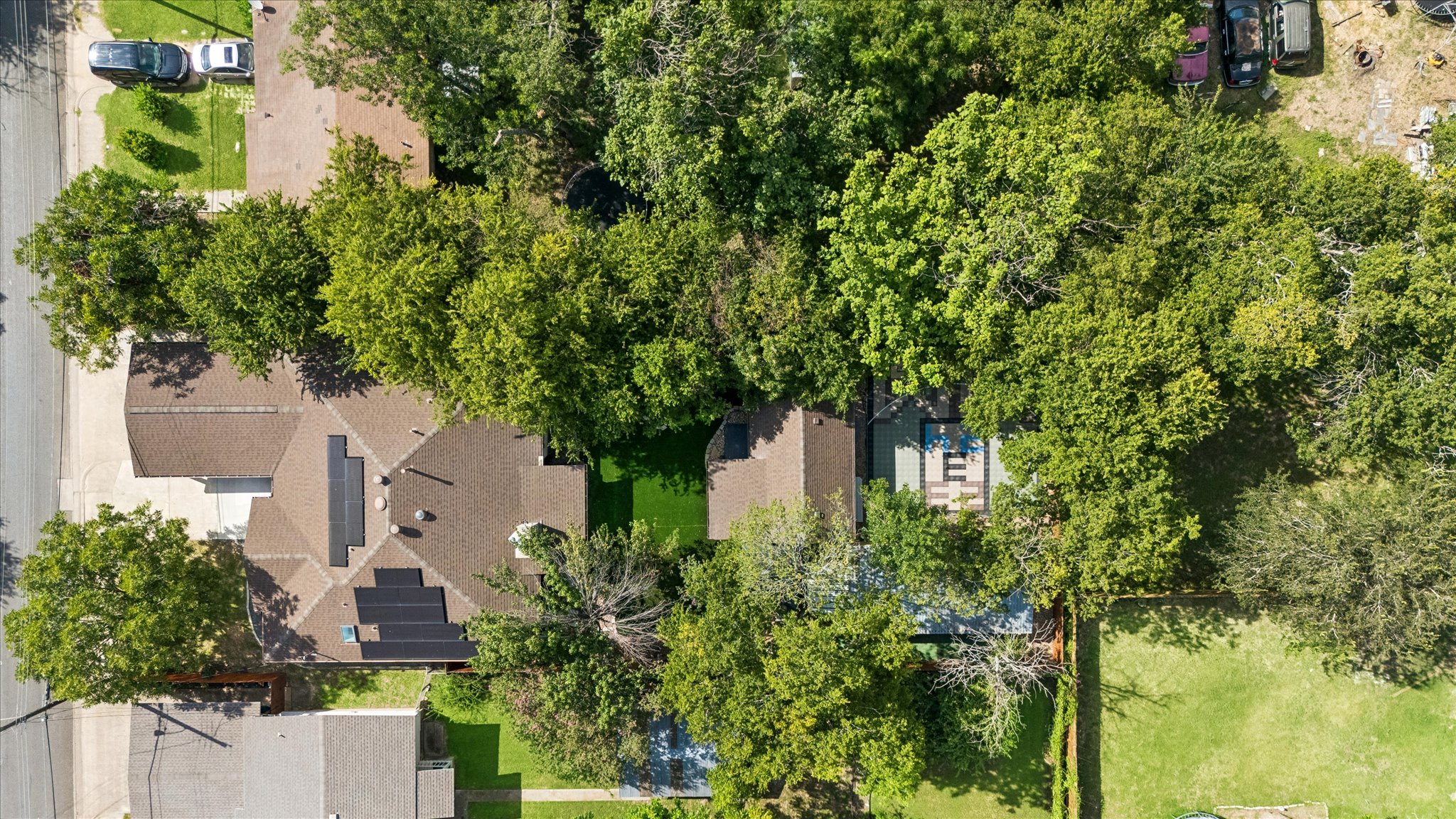 1706 Davis Street Taylor, TX 76574 - Photo 17 of 18 An aerial perspective showcases a residential lot framed by mature trees, highlighting a private yard and solar panels.