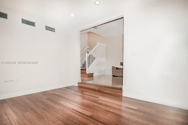 a view of entryway and hall with wooden floor