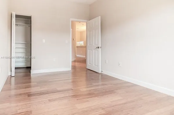 a view of empty room with wooden floor