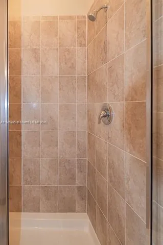 a bathroom with a sink shower and a mirror