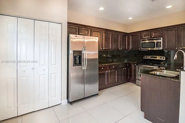 a kitchen with stainless steel appliances granite countertop a refrigerator and a sink