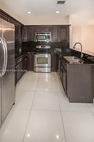 a kitchen with stainless steel appliances granite countertop a sink and a stove top oven