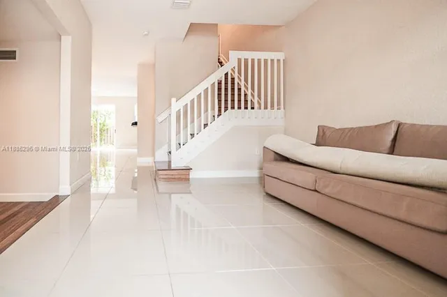 a living room with furniture and stairs